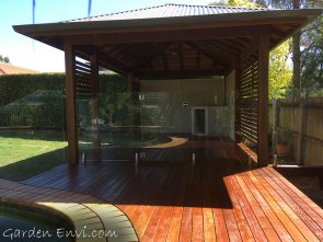 Spotted Gum Gazebo with multiple features including solid Spotted Gum Posts, two framed and sided walls, Spotted Gum screening, Cedar ceiling, exposed F27 Spotted Gum rafters, Colorbond Roof, elevated deck set to the height of the pool surround with Merbau decking fit to curve around the pool.