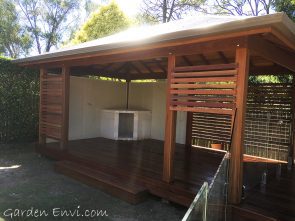 Spotted Gum Gazebo with multiple features including solid Spotted Gum Posts, two framed and sided walls, Spotted Gum screening, Cedar ceiling, exposed F27 Spotted Gum rafters, Colorbond Roof, elevated deck set to the height of the pool surround with Merbau decking fit to curve around the pool.